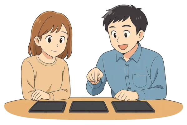 二人で机の上に第8・第10・第11世代iPadを並べて比べている。 ひろとが指差しで説明。 ひなは「なるほど～」と感心している。